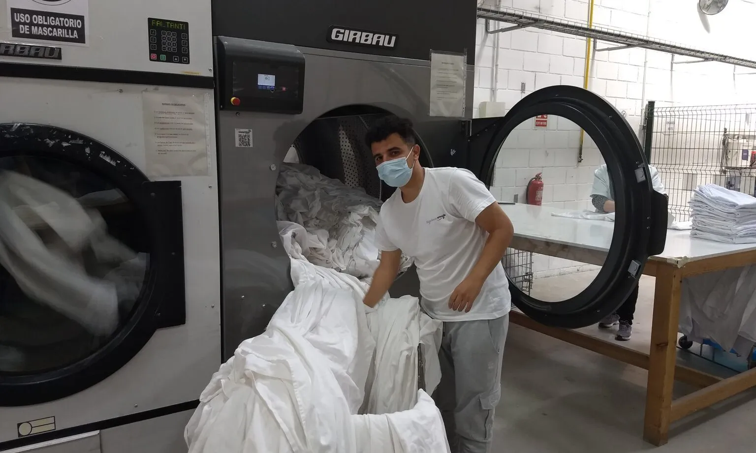 Un dels joves de Formació i Treball fent pràctiques a la bugaderia del Garraf.