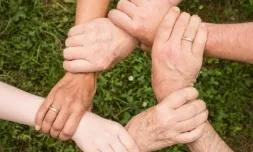 Un grup de gent entrellaçant les mans.