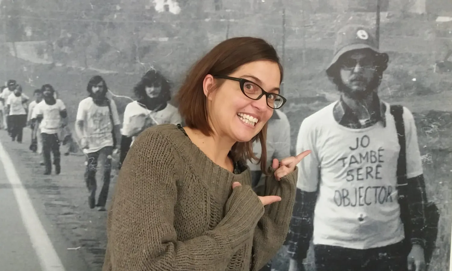 Barbeito amb una foto històrica d'una marxa per l'objecció de consciència que està exposada a la seu de l'ICIP (Institut Català Internacional per la Pau).