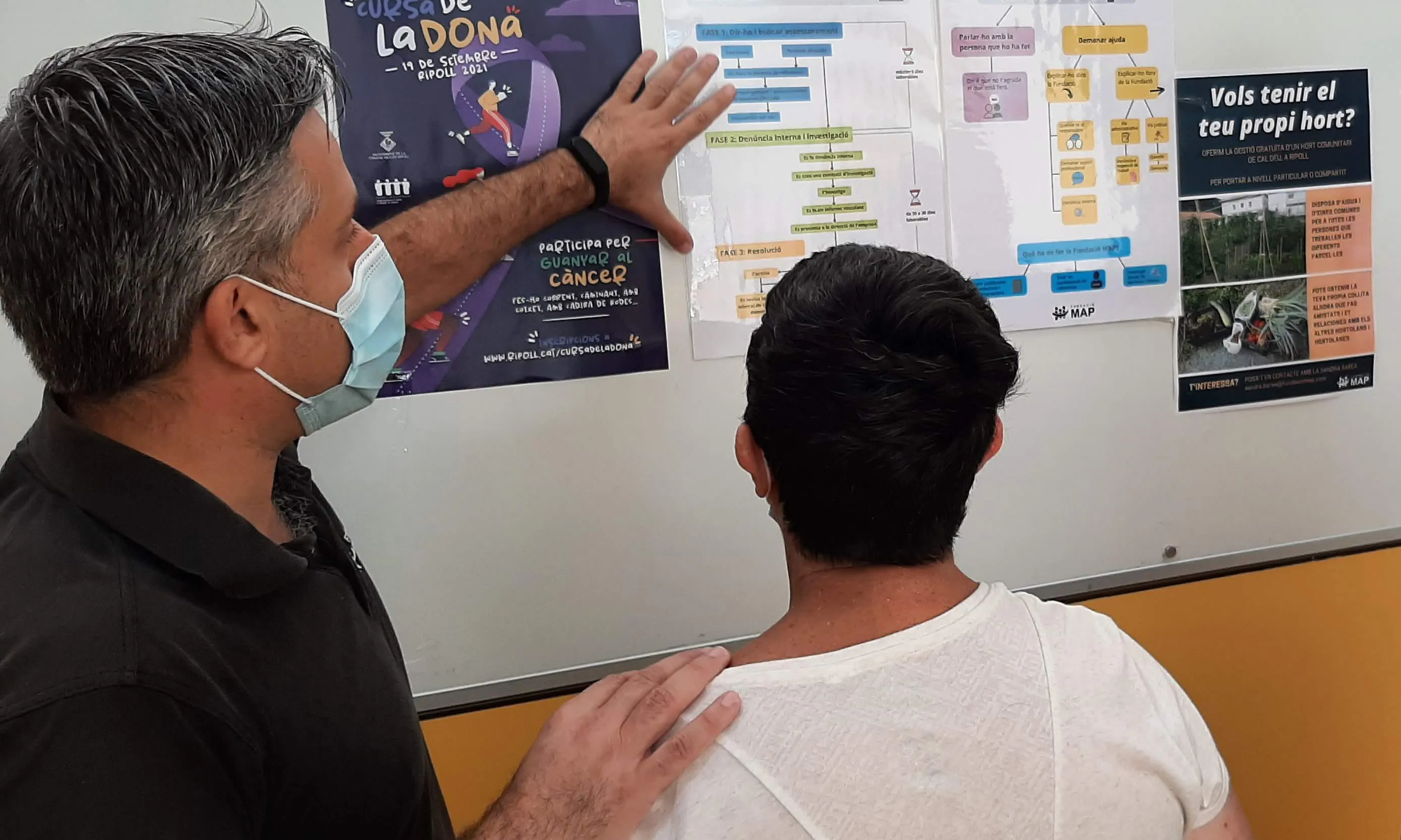 Un usuari de la Fundació MAP llegeix el cartell del protocol en prevenció d'abús