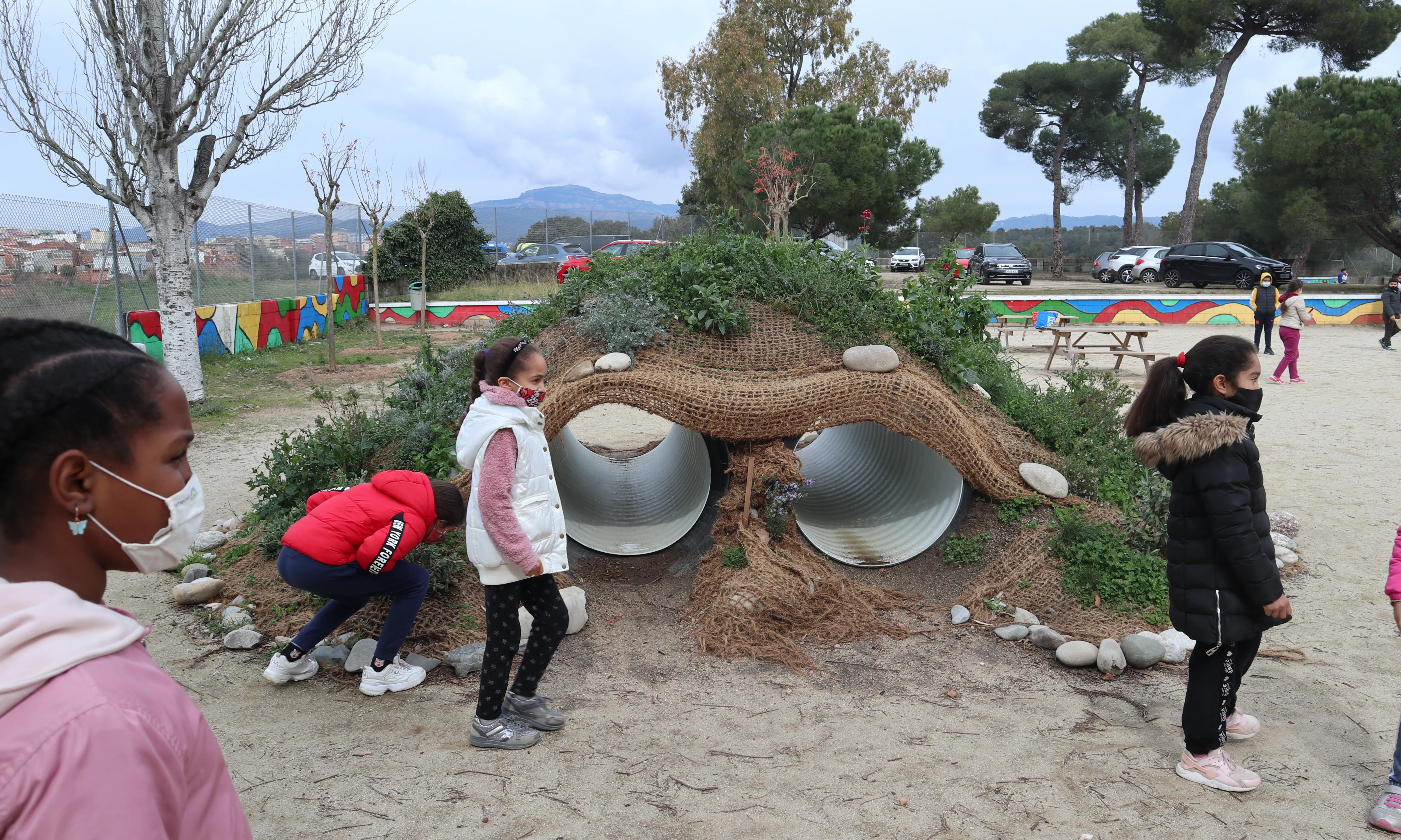 Un grup d'infants participen en un dels tallers a l'aire lliure de pedagogia urbana, en el qual formen un espai de jocs amb materials naturals