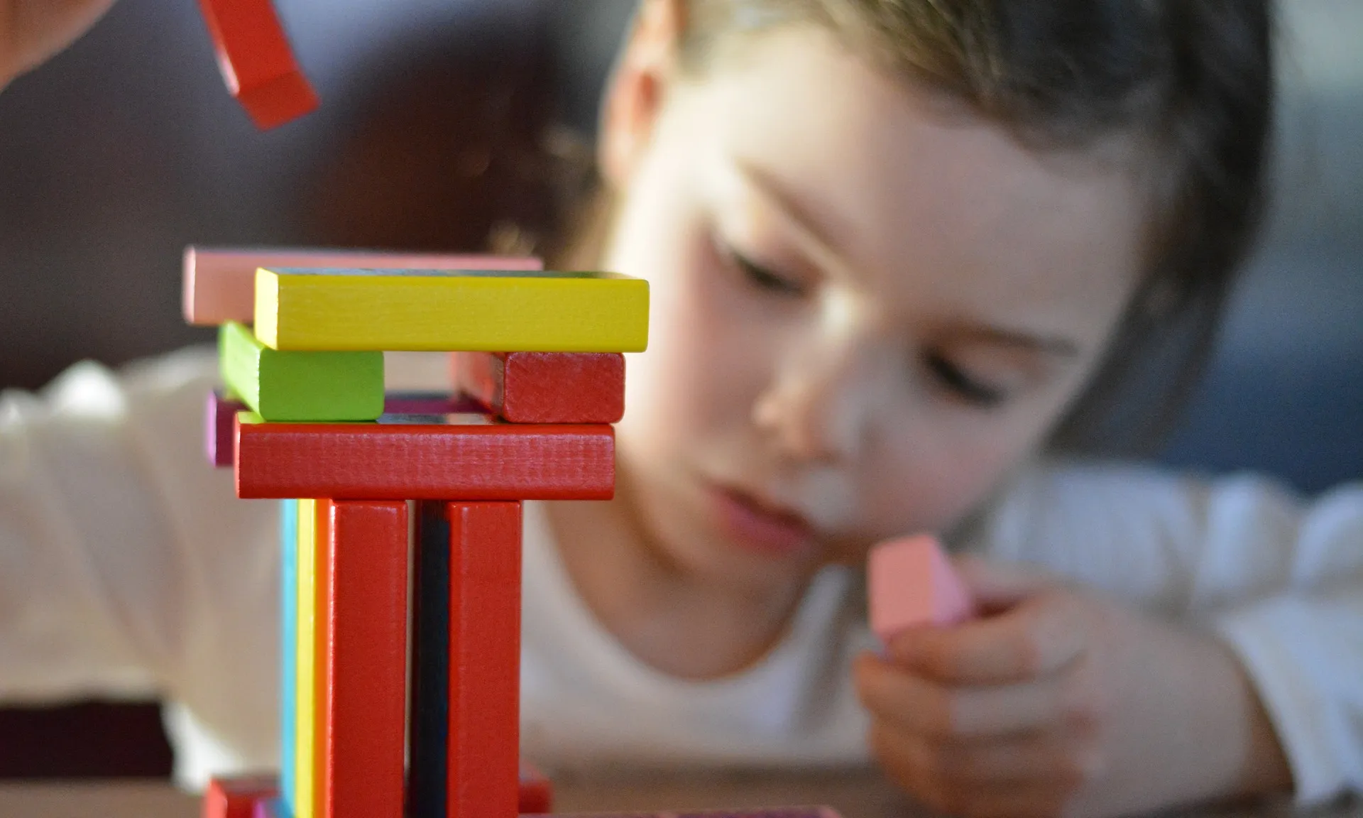 Un infant juga amb un joc de construccions.