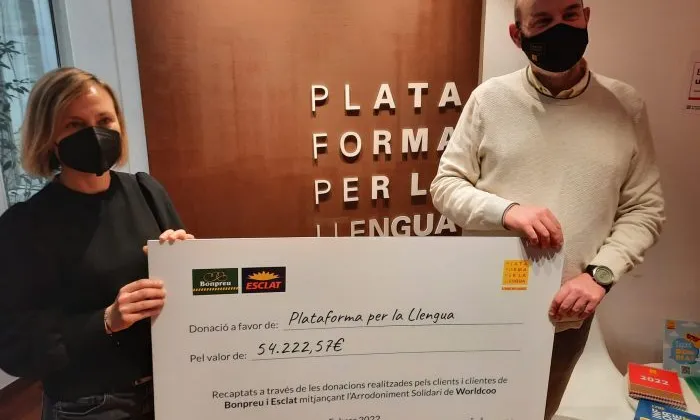 El president de Plataforma per la Llengua, Òscar Escuder, rep el xec amb les donacions per redoblar esforços perquè el català sigui més present a les plataformes de vídeo a la carta.