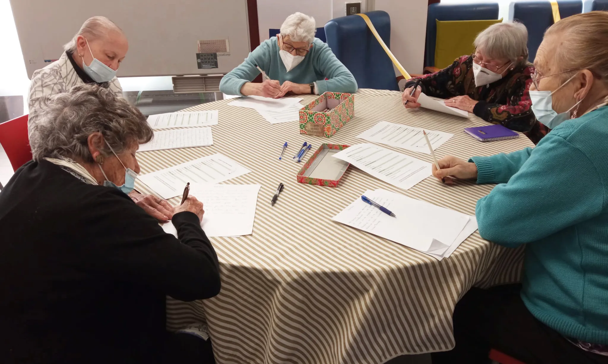 Persones grans que acompanya la Fundació Roure en el moment d'escriure les cartes per als nois i noies de la Fundació Comtal.