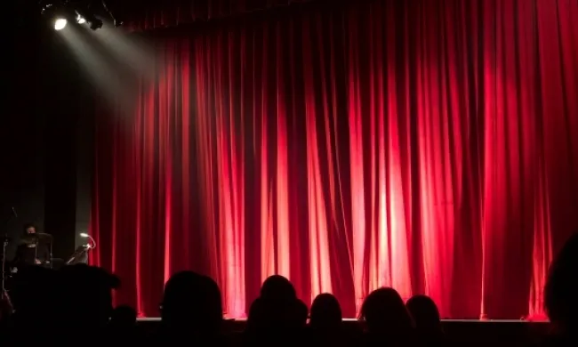 Imatge d'unes persones a punt de gaudir d'una obra de teatre. Font: Llicència CC Pexels