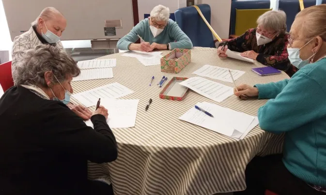 Persones grans que acompanya la Fundació Roure en el moment d'escriure cartes per als nois i noies de la Fundació Comtal.