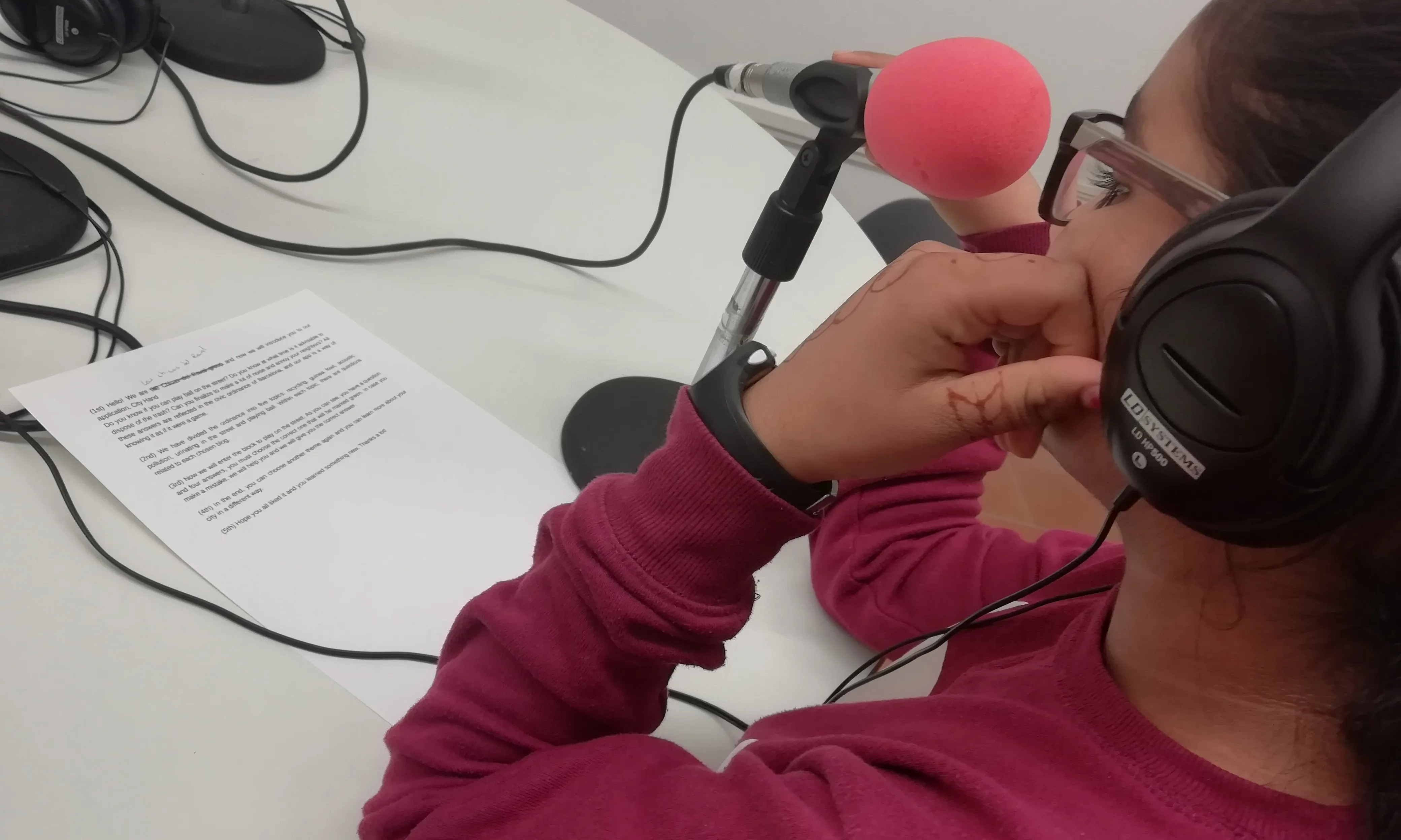 Una jove gravant a la ràdio comunitaria de Colectic.