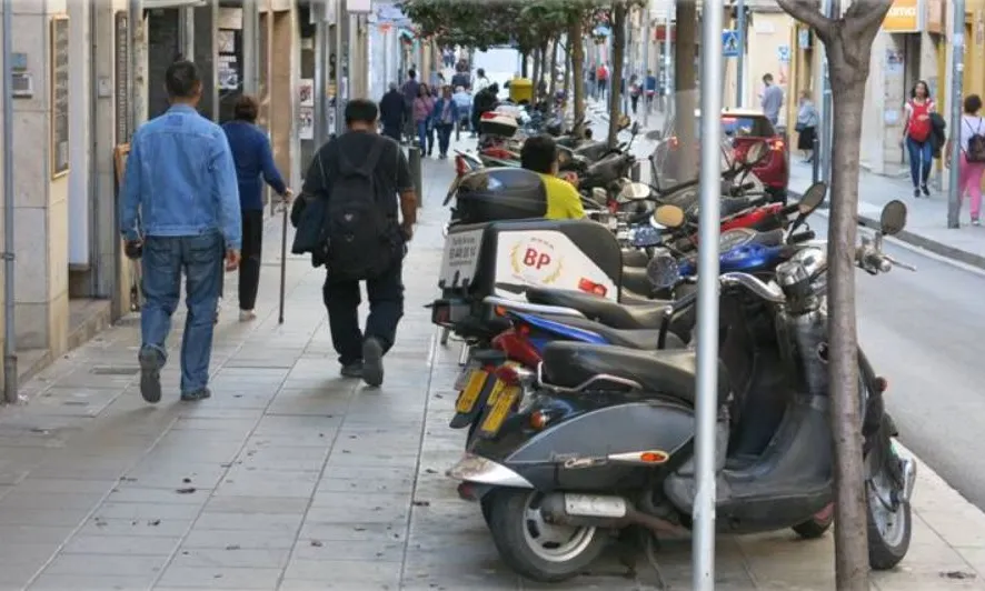 Imatge compartida per Catalunya Camina en la qual es veuen diverses motos mal estacionades a la vorera.
