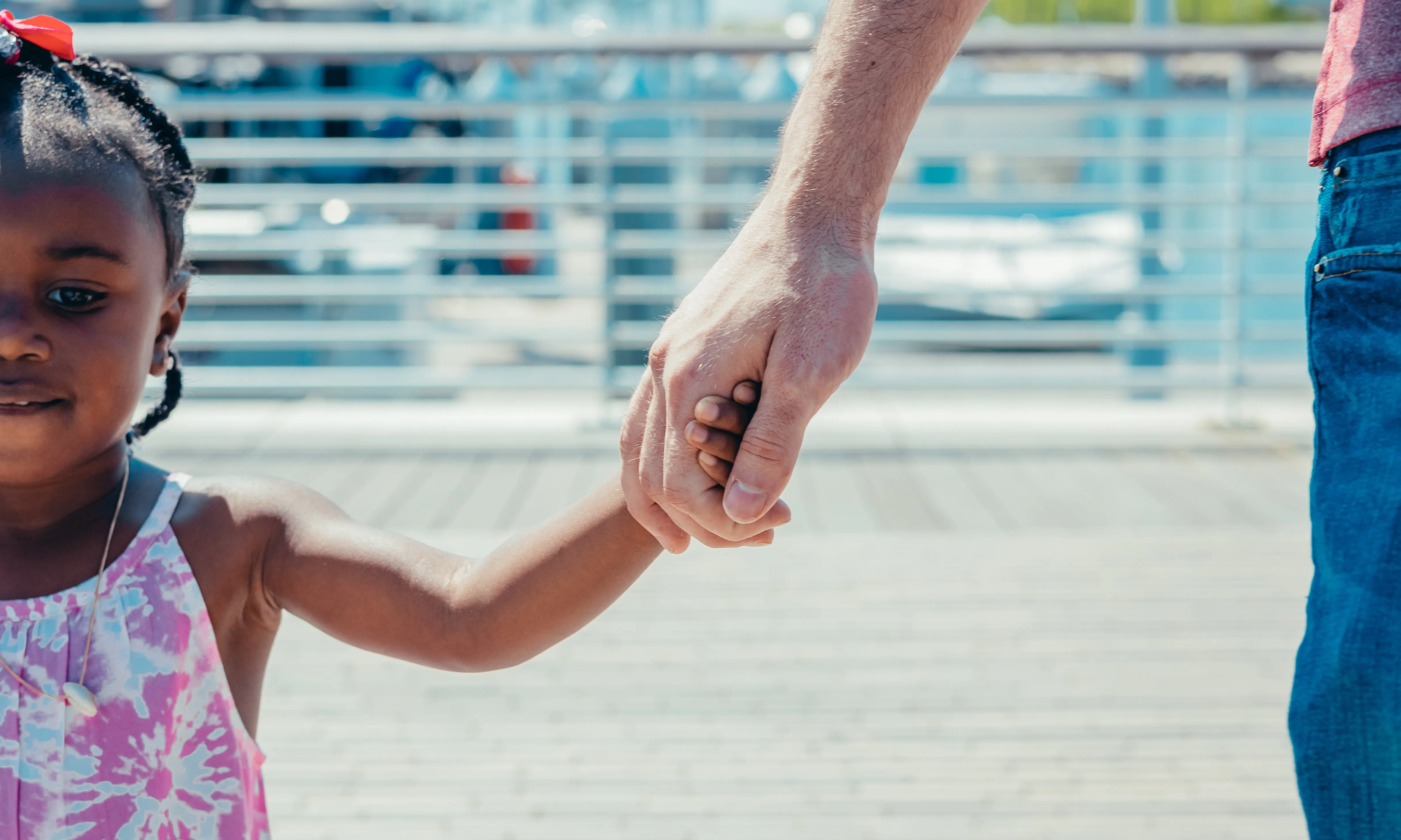 Un adult agafant la mà d'un infant. Font: Pexels - Kindel Media