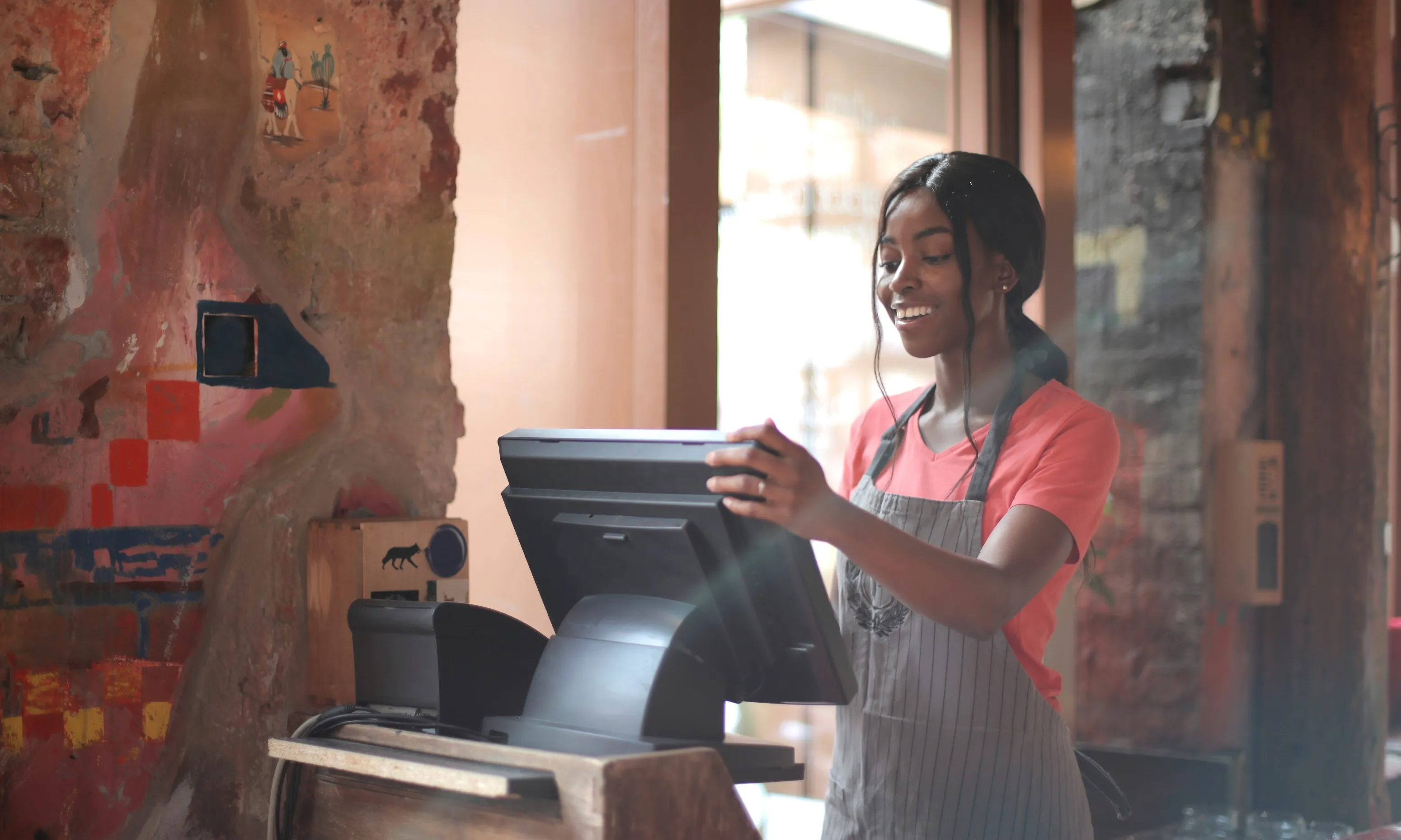 Noia treballant en una caixa d'un restaurant. Font: Pexels - Andrea Piacquadio