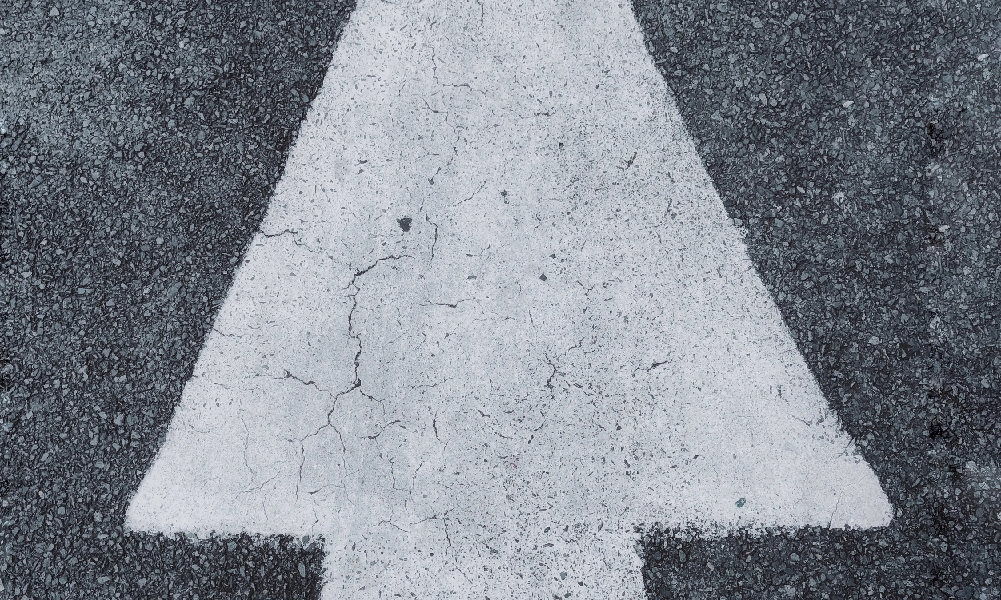 Persona seguint una fletxa a la carretera. Font: Pexels - Vicky Tran