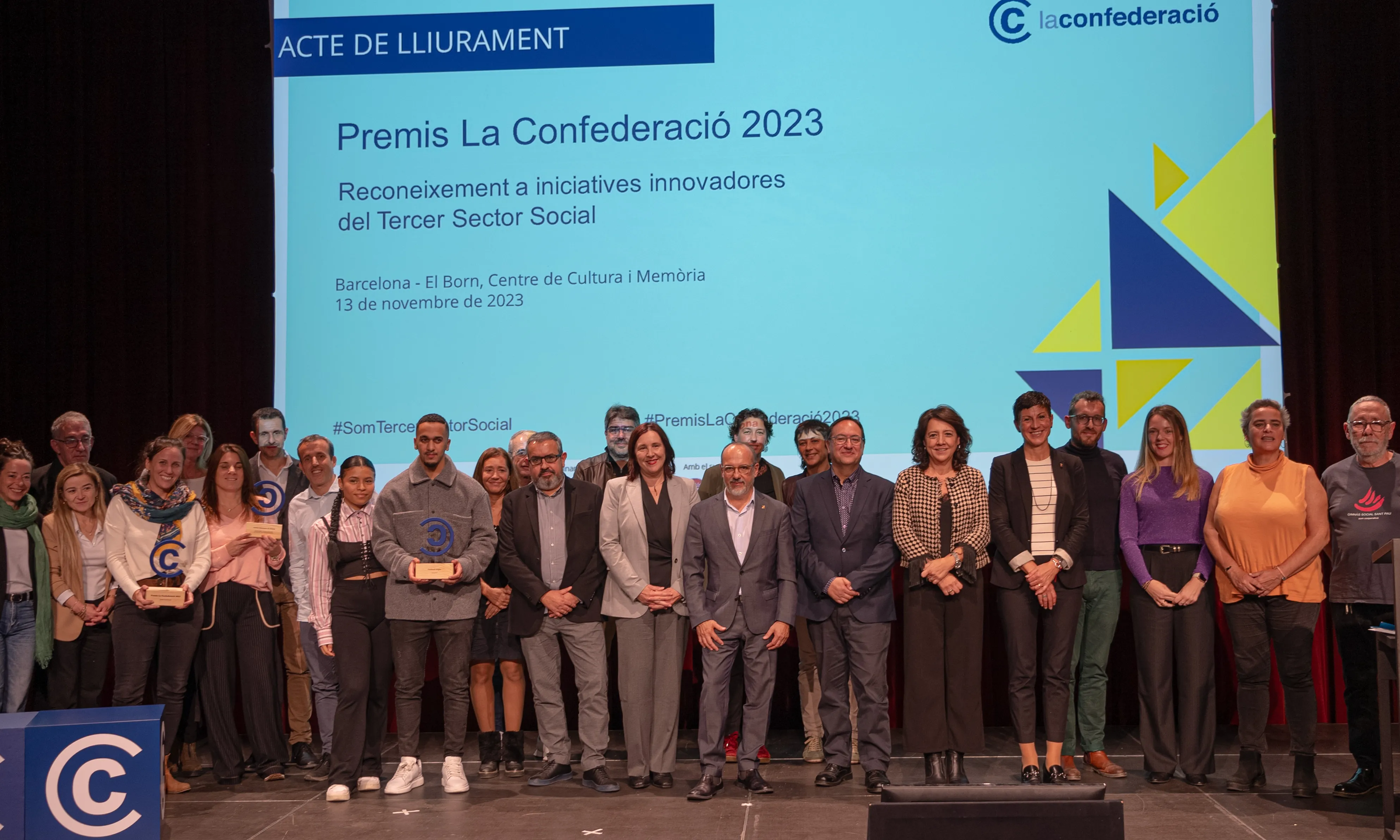 Foto de família a dalt de l'escenari de l'equip de La Confederació i de les entitats premiades.