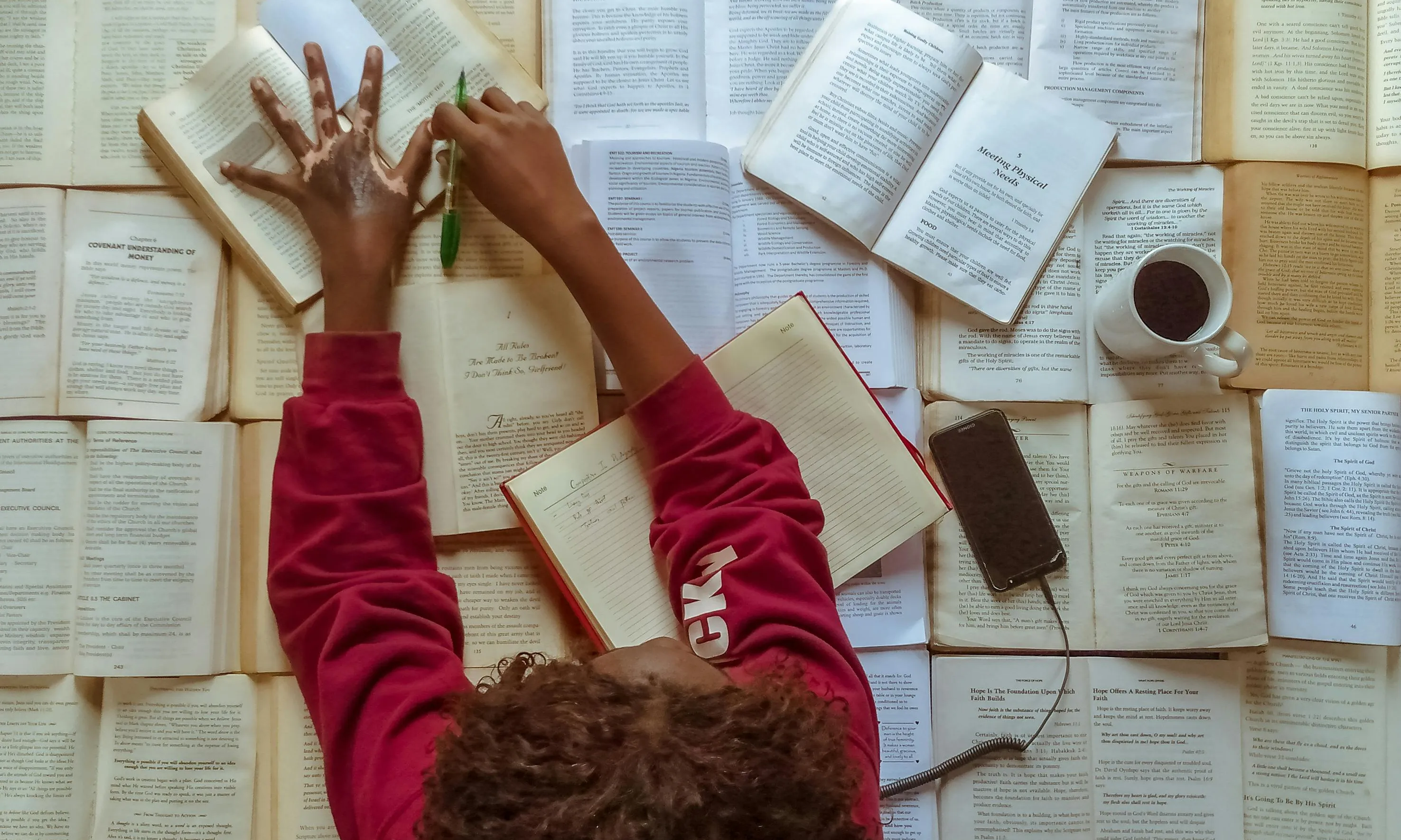 Persona llegint molts llibres. Font: Pexels - Adegbenro Emmanuel Persona llegint molts llibres. Font: Pexels - Adegbenro Emmanuel