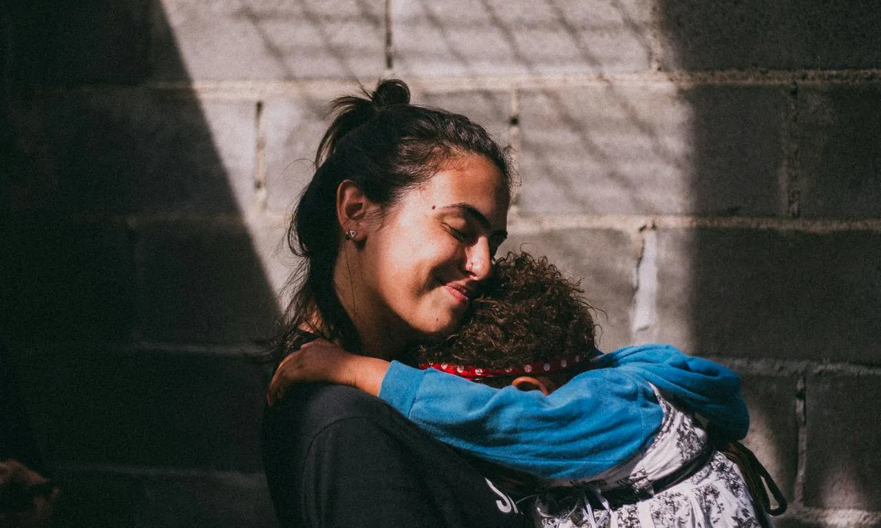 Noia abraçant a un infant. Font: Pexels - Edward Eyer