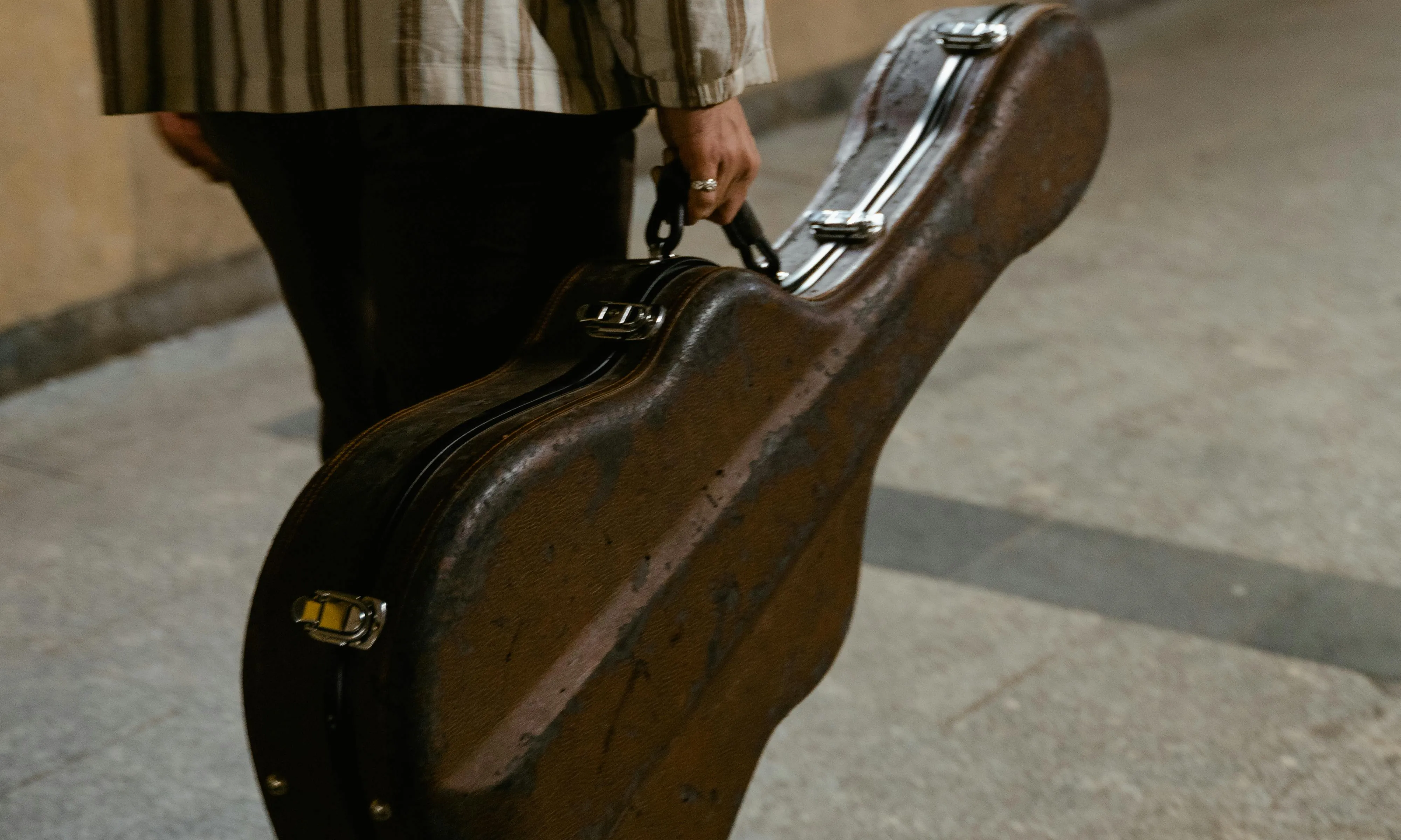 Persona transportant una guitarra en un metro. Font: Pexels - MART PRODUCTION Persona transportant una guitarra en un metro. Font: Pexels - MART PRODUCTION