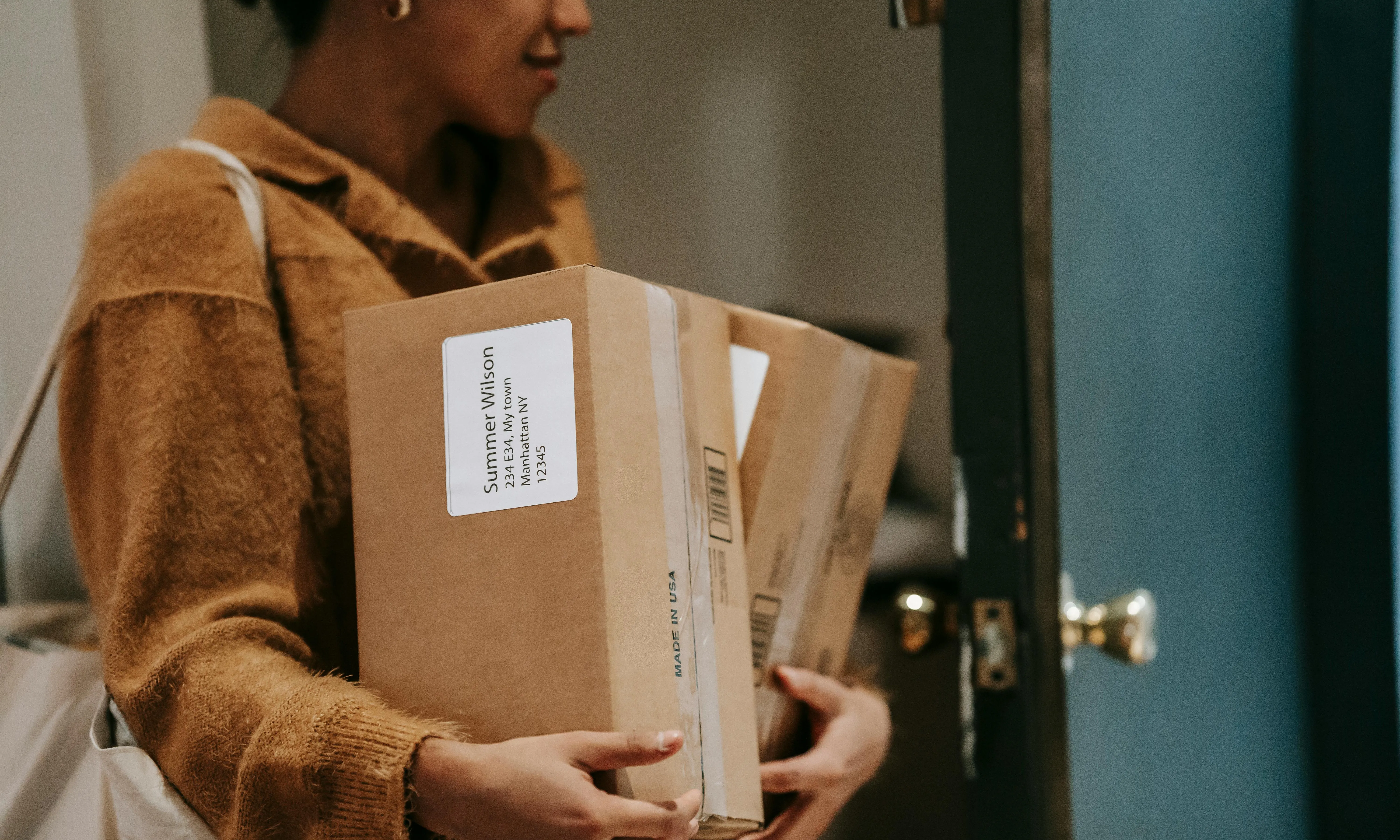 Persona amb caixes i paquets arribant a casa. Font: Pexels - Liza Summer