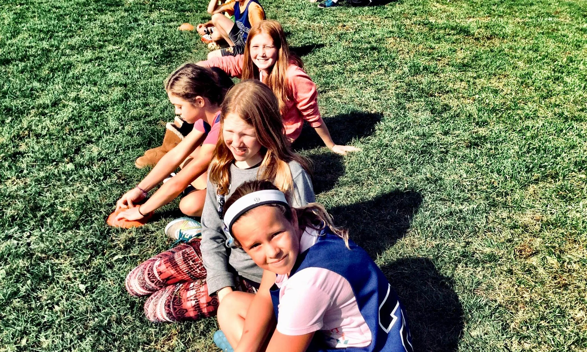 Infants asseguts en un camp de gespa. Font: Pexels - Anny Patterson