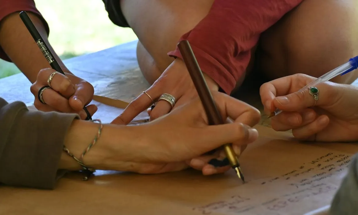 Diverses mans escriuen sobre un paper d'embalar, en una activitat de formació