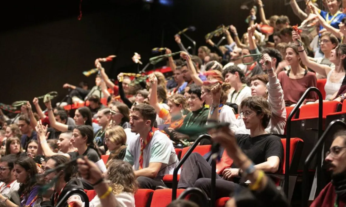 Caps aplaudeixen i fan voleiar els fulards, celebrant l'aprovació d'un dels punts de l'Assemblea