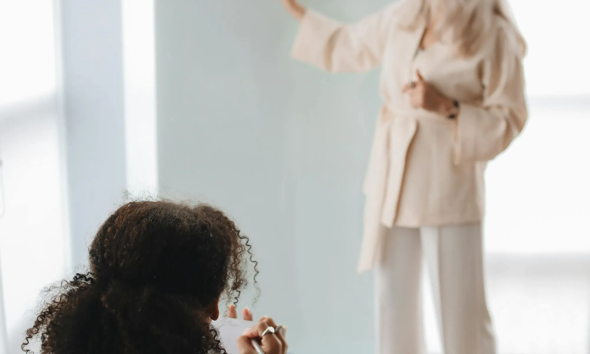 Dona donant classe i alumna escoltant