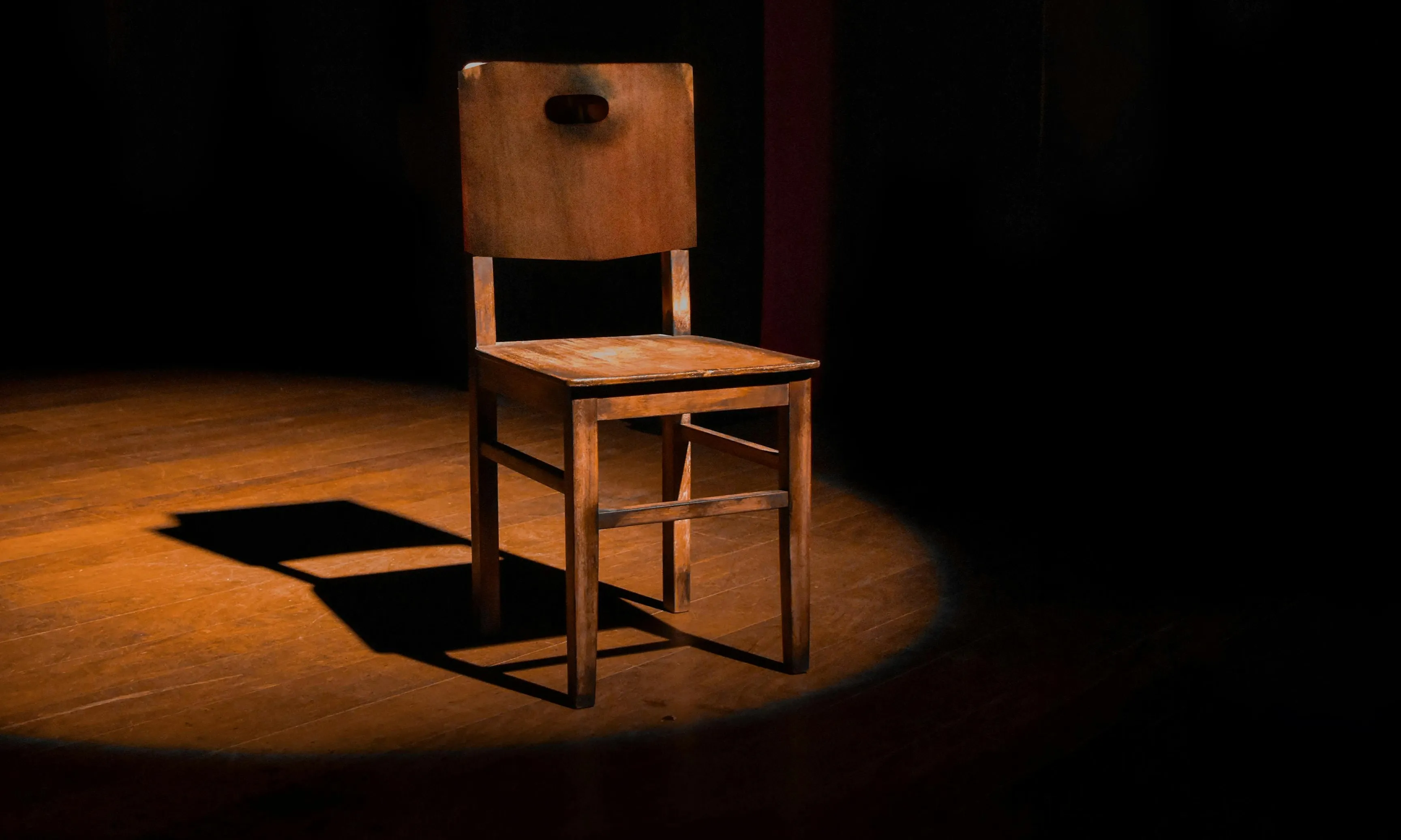 Cadira il·luminada dalt d'un escenari de teatre