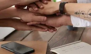 Equip de treball amb les mans unides