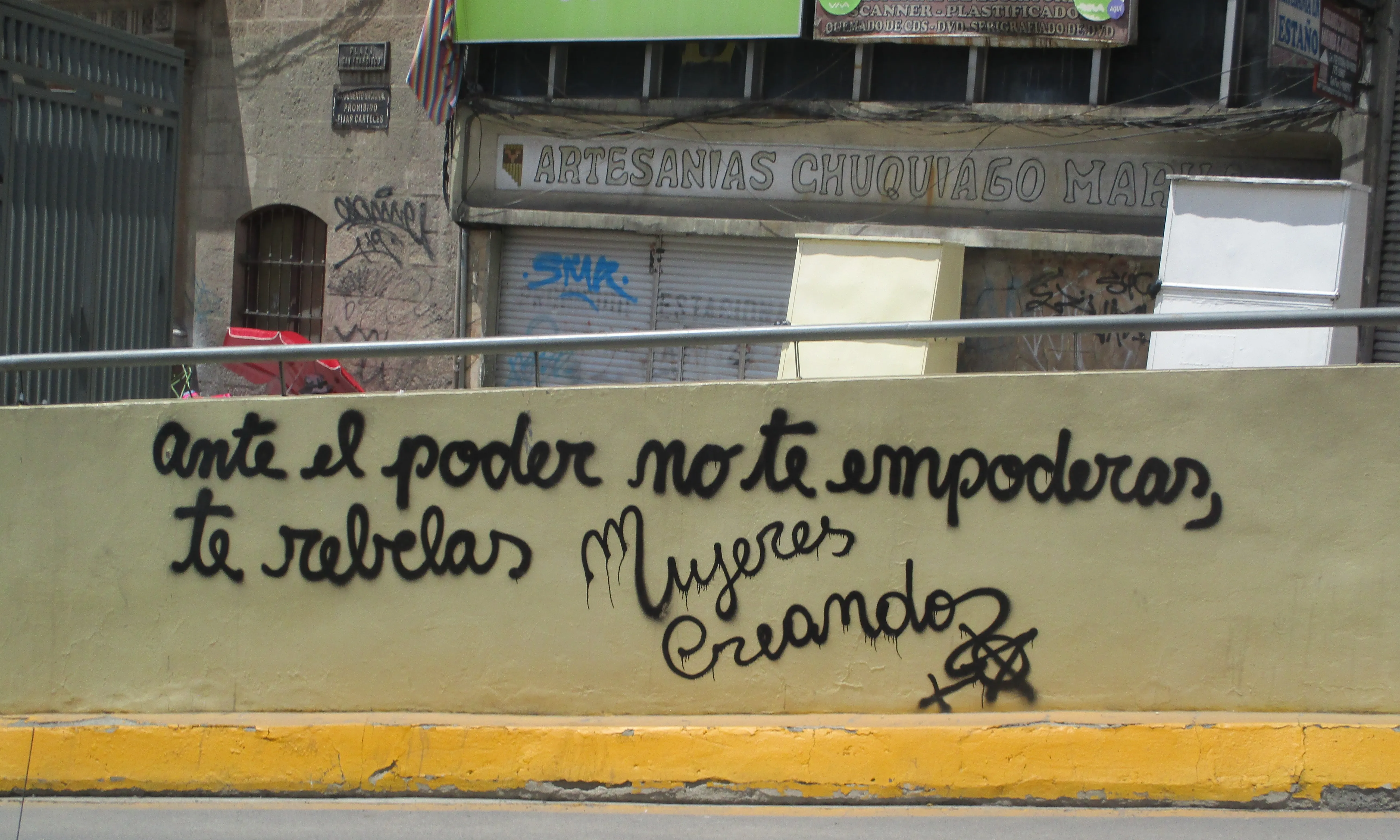Graffiti en una paret del carrer que diu 'Ante el poder no te empoderas, te rebelas'.
