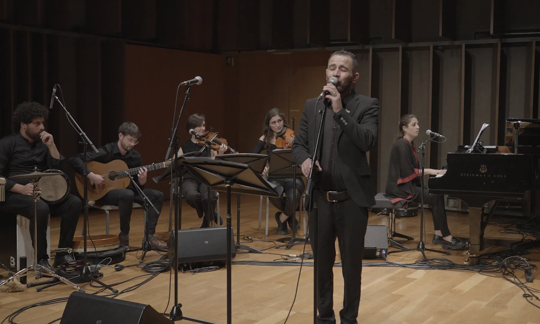 Vista del concert 'Paisatges sonors', amb el cantant en primer pla i els músics en segon pla.