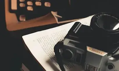 Taula amb una màquina d'escriure, papers i una càmera