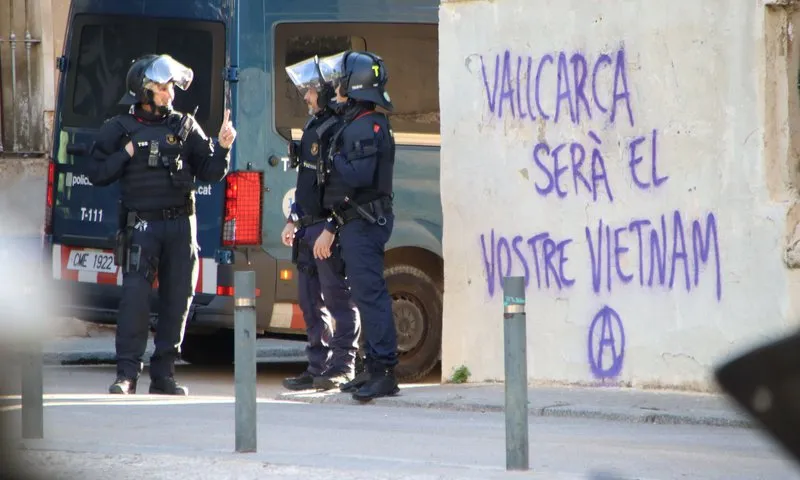 Imatge de policies estacionats a un carrer de Vallcarca amb una pintada antifeixista