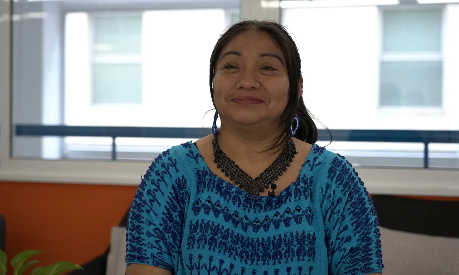 Pla americà de la María Caal, activista de Guatemala, mirant a càmera i somrient.