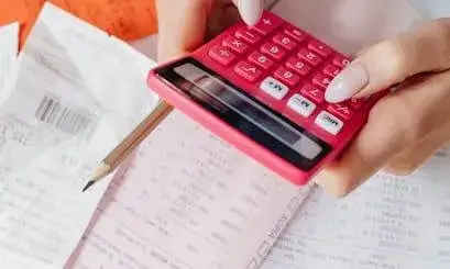Finançament Persona amb documentació fent càlculs amb una calculadora