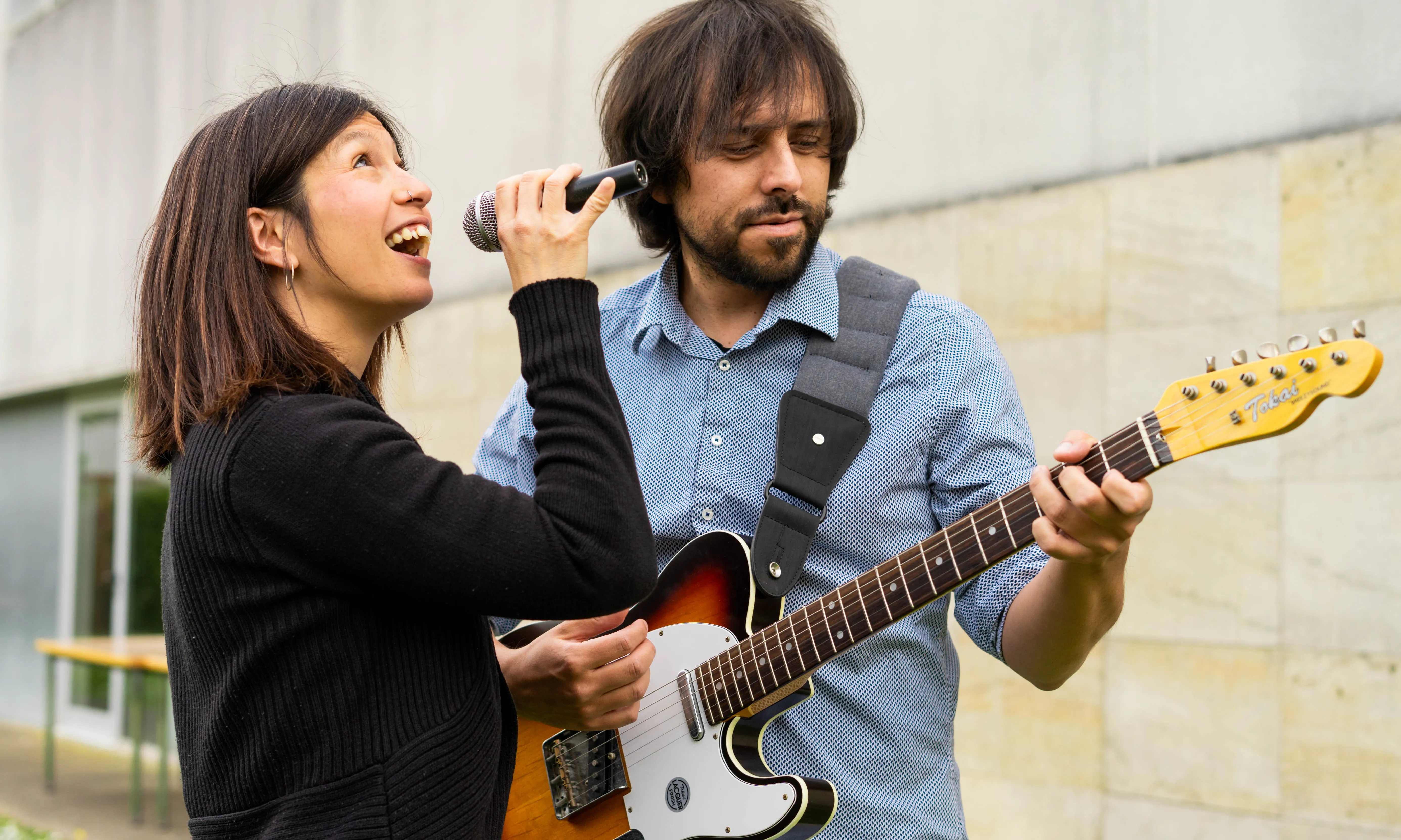 Dona cantant i home tocant la guitarra.