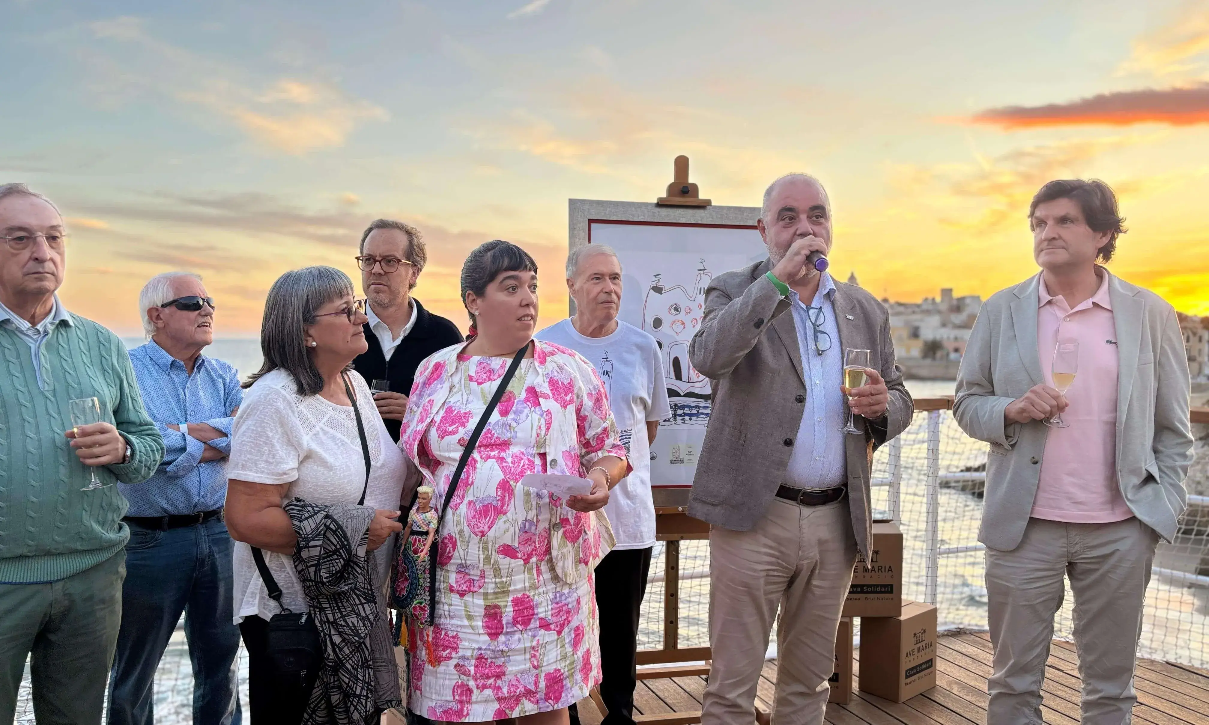 Acte de presentació del cava solidari de la Fundació Ave Maria, amb participants brindant en un entorn festiu a la vora del mar