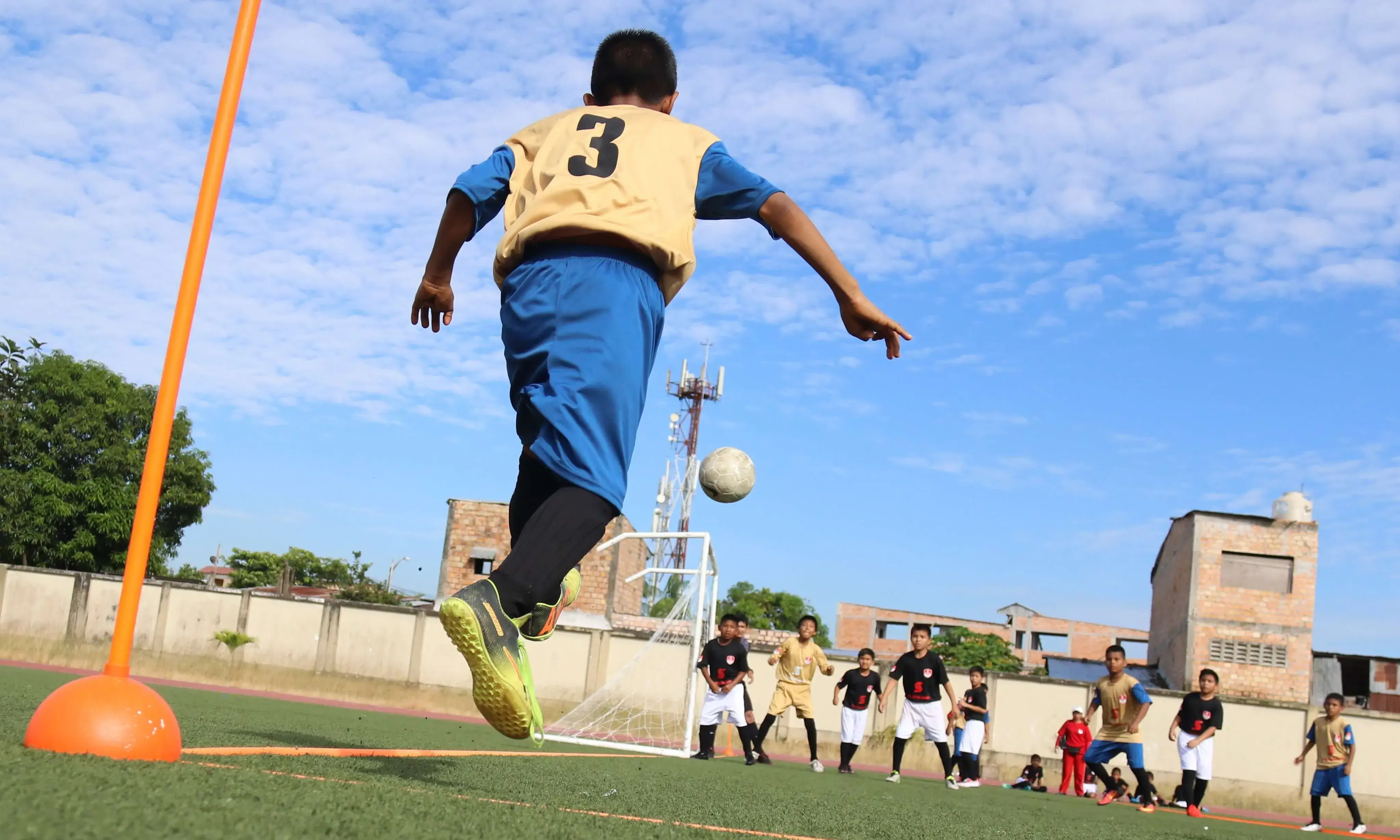 Nens jugant a futbol fent una activitat extraexcolar