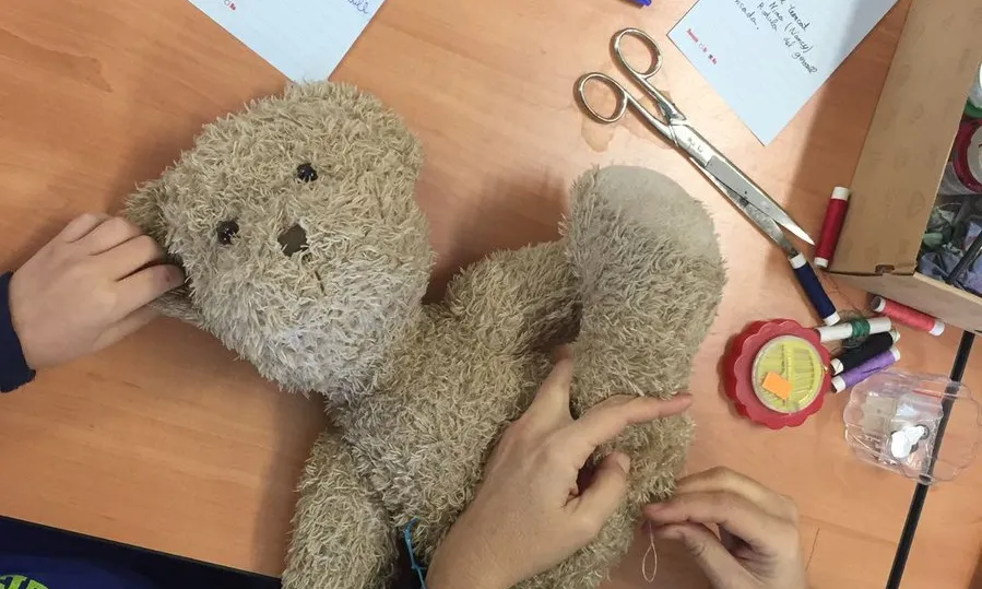 Infants reparant un peluix. 