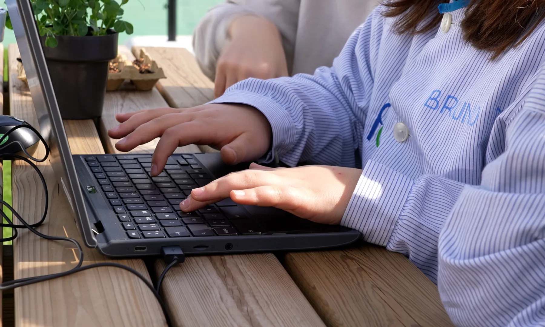 Un infant està utilitzant un ordinador portàtil.