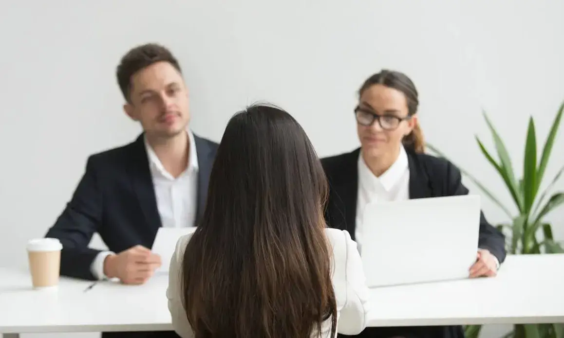 Un home i una dona entrevistant una dona