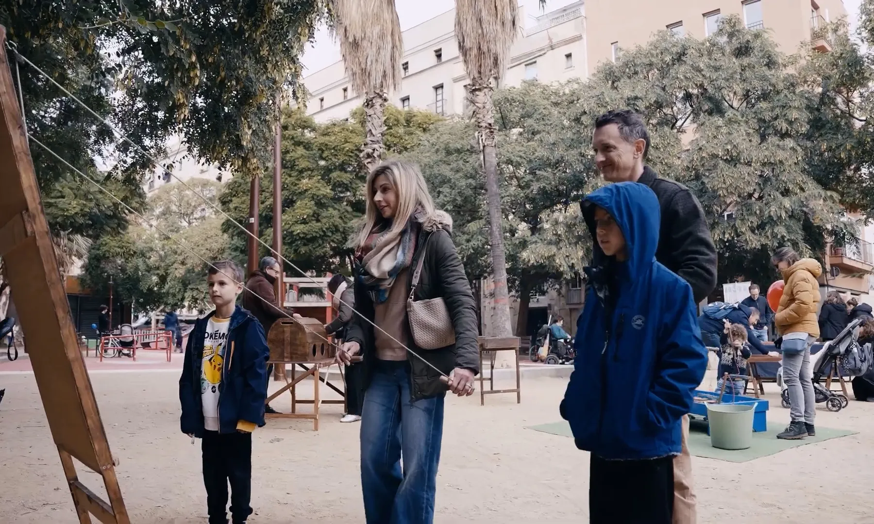 Una família jugant a un joc tradicional en un parc de Barcelona.