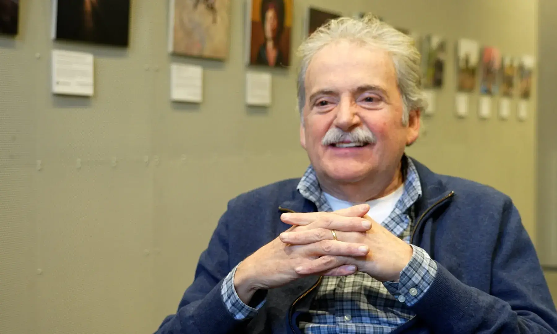 Frederic Callís, president de l'Associació Gràcia Solidària, assegut en una cadira i somrient a càmera.