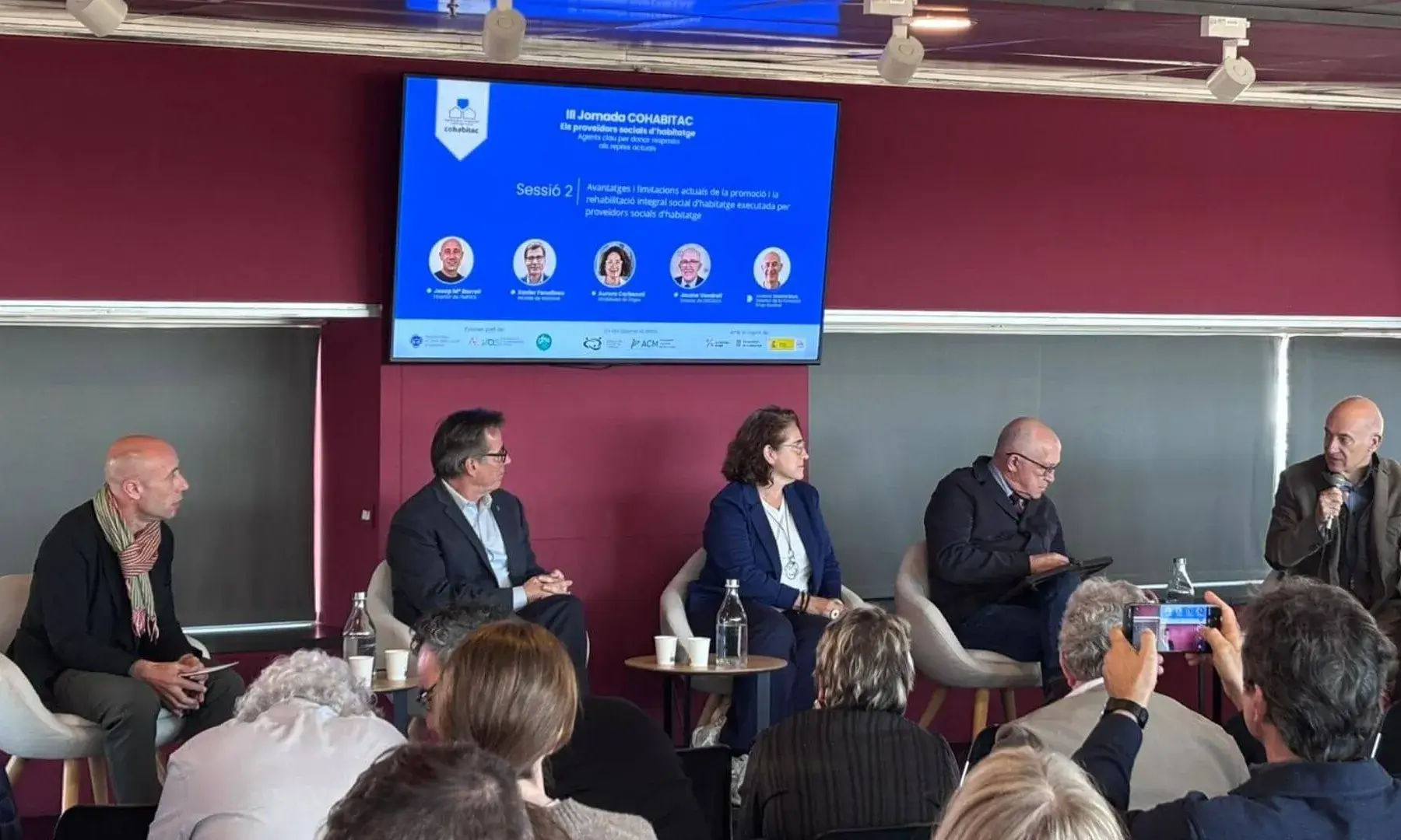 Taula rodona de la III Jornada COHABITAC amb diversos ponents debatent sobre habitatge social davant del públic assistent.