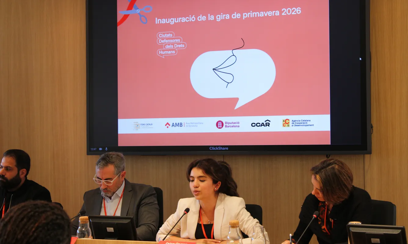 Zaina Qazzaz com a cap de taula en una conferència fent un discurs.
