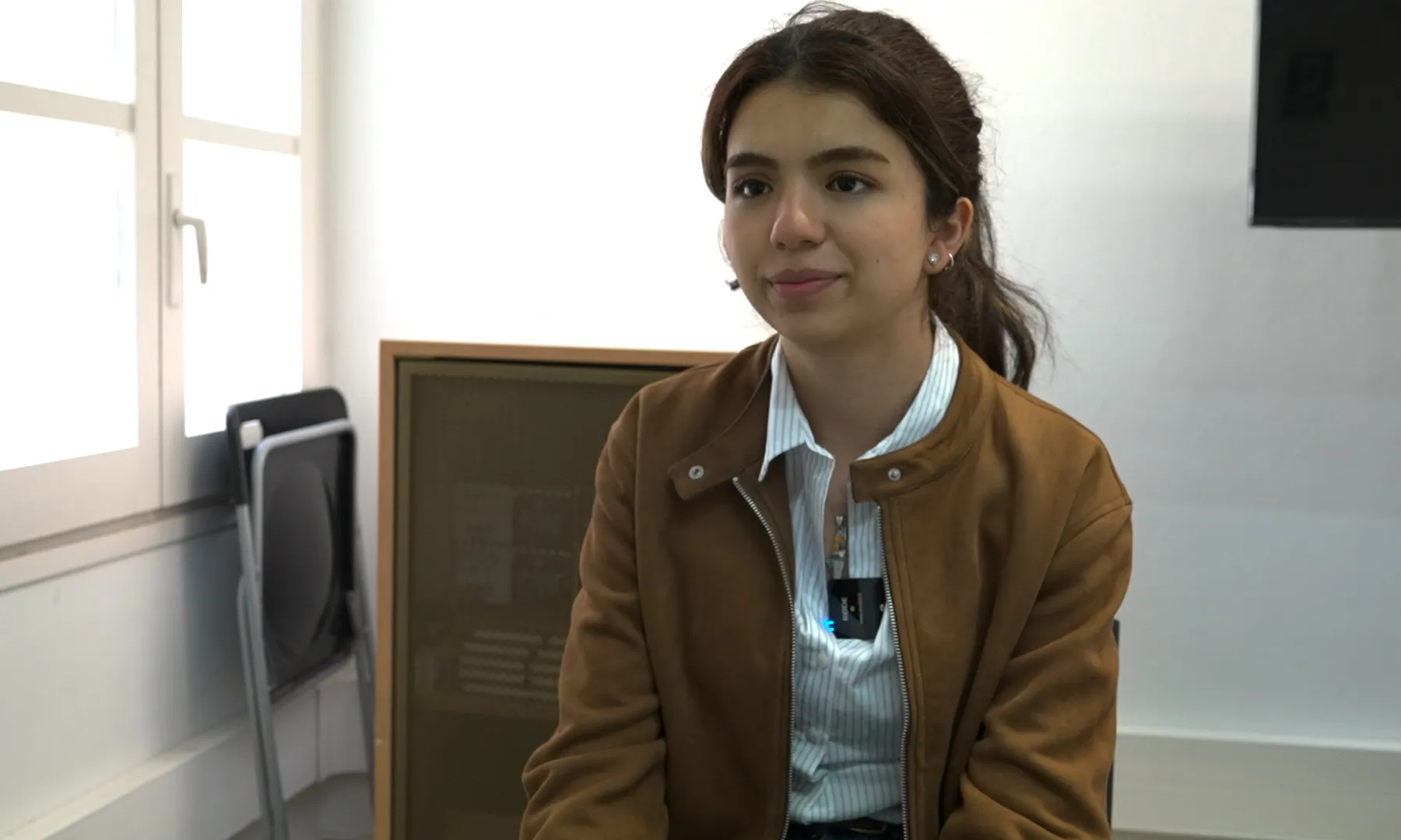 La Zaina asseguda en una cadira, en pla americà, somrient a càmera.