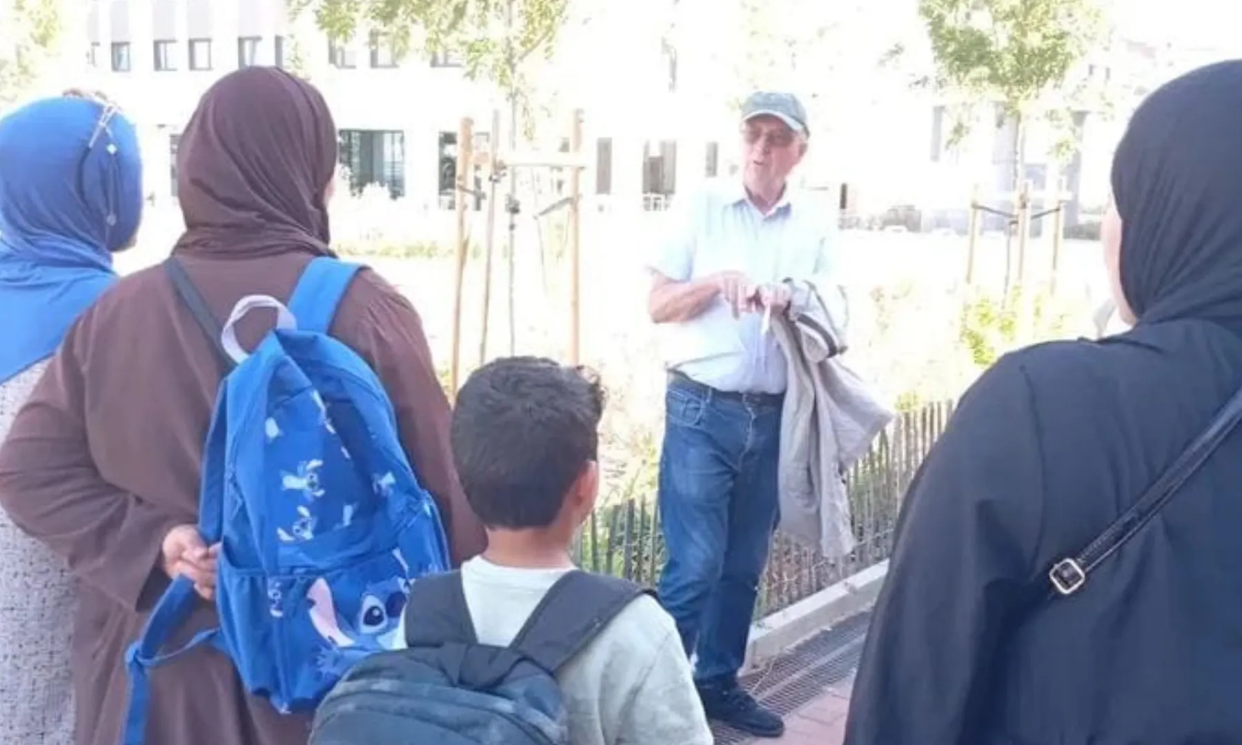 Diverses persones adultes i un infant escolten les explicacions d’un home durant una activitat a l’aire lliure al barri d’Ègara.