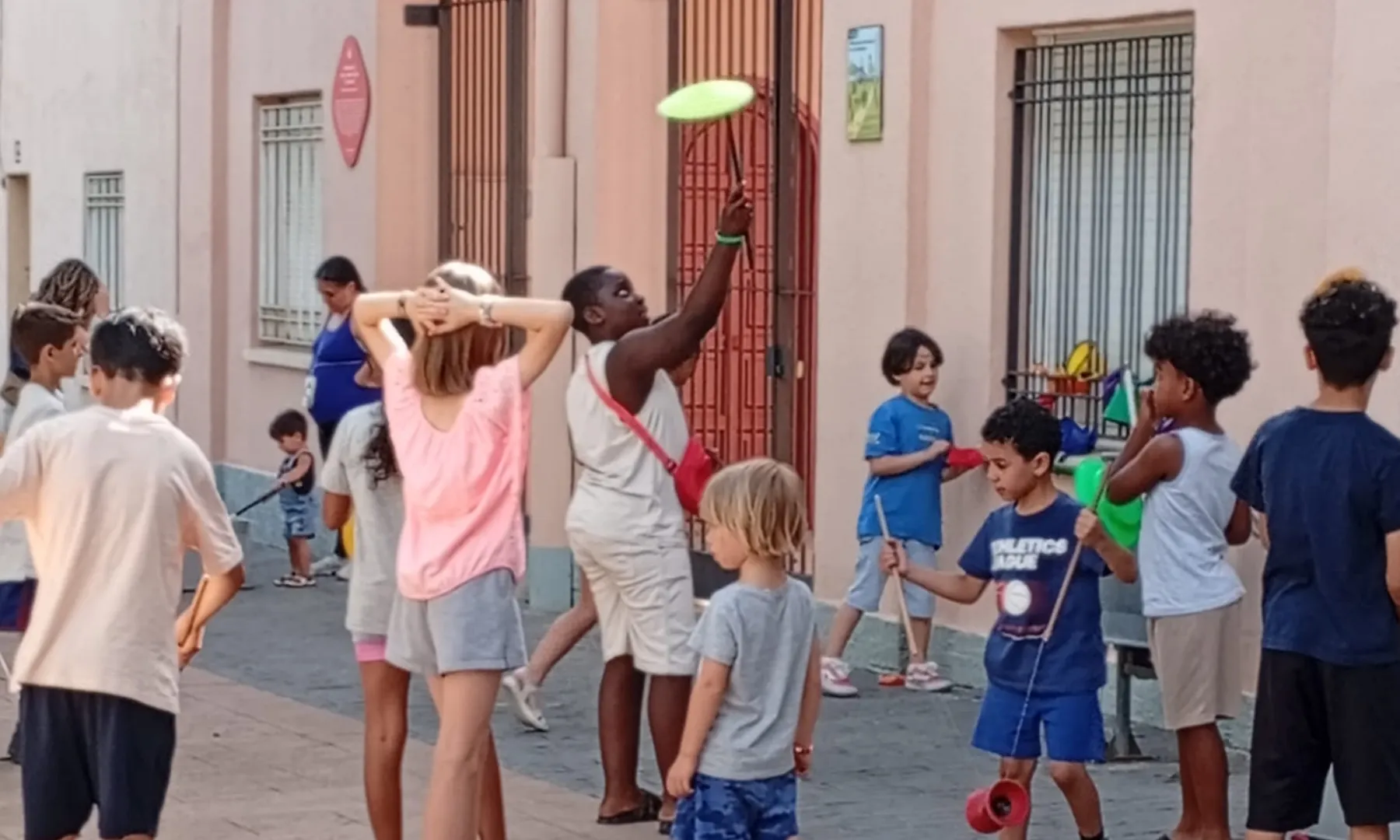 Un grup d’infants participa en diverses activitats i jocs a l’aire lliure en un carrer del barri d’Ègara.