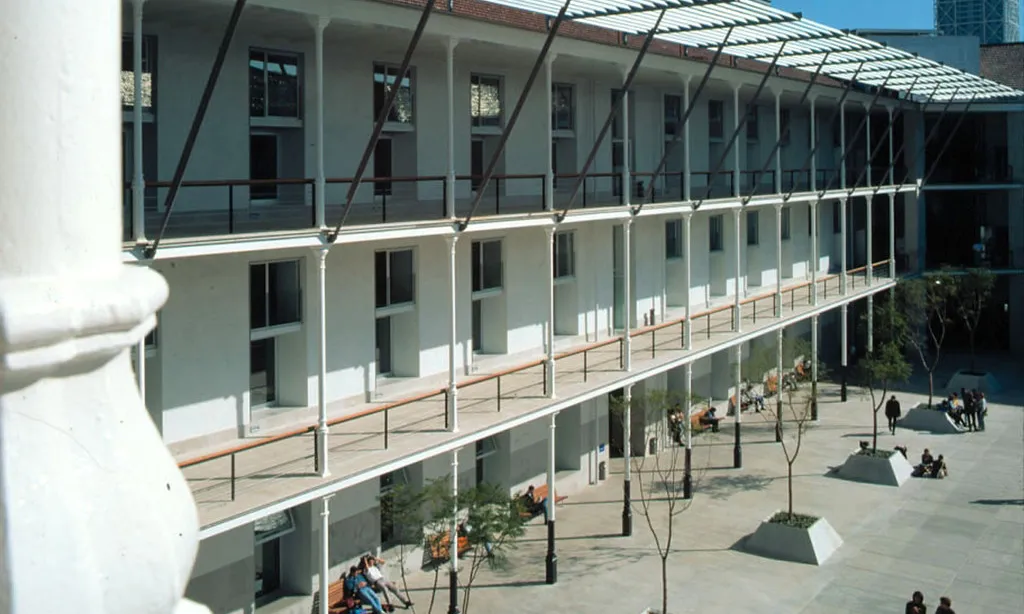 Un dels campus de la Universitat Pompeu Fabra, amb una façana amb balcons i un pati amb estudiants.