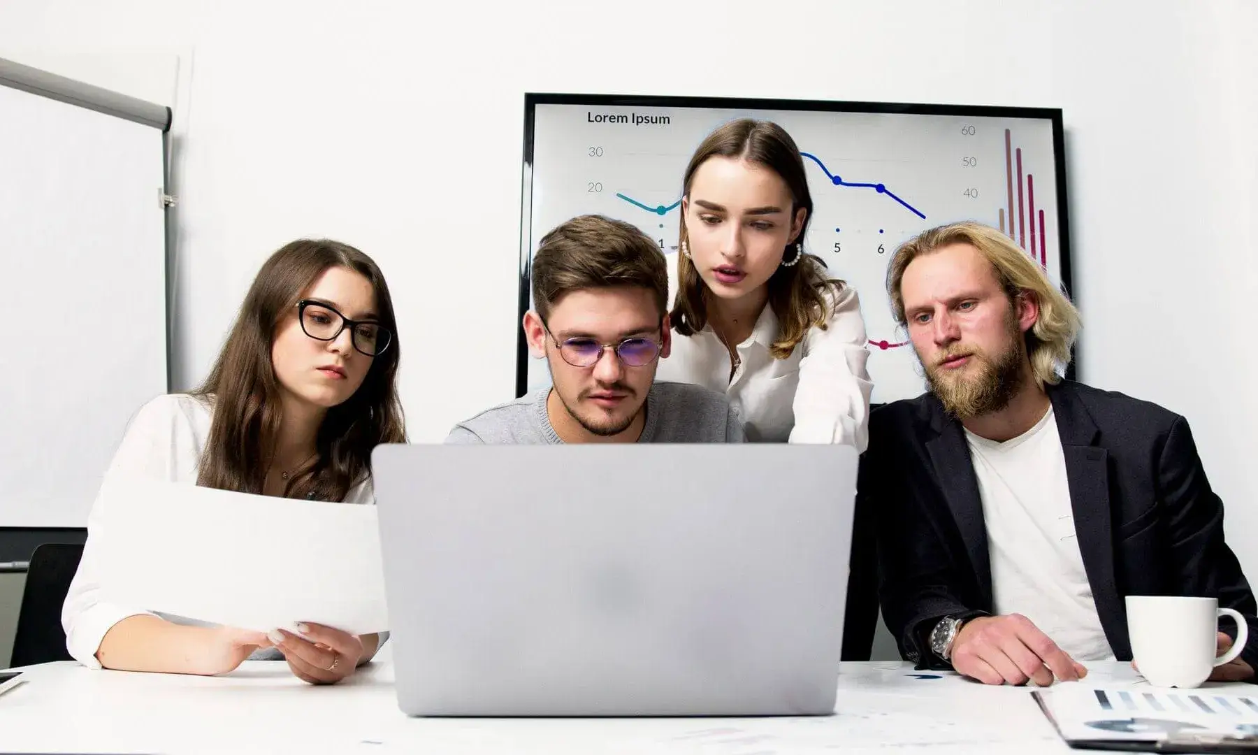 Un equip d'empresa participa en una reunió col·laborativa fent servir un portàtil