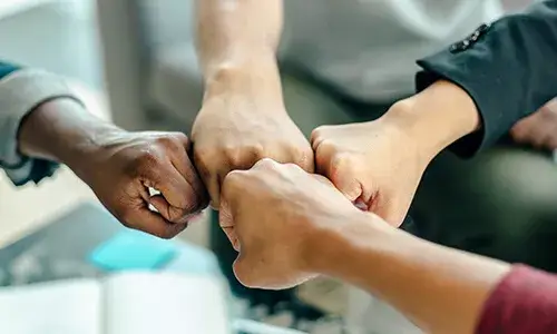 Punys de diferents persones units en un sol punt