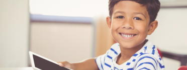 Un nen agafa una tablet a casa per poder continuar amb la seva rutina escolar. Font: Fundació IRES