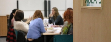 Porta obert a un aula amb dones reunides al voltant d'una taula Font: Fundació Surt